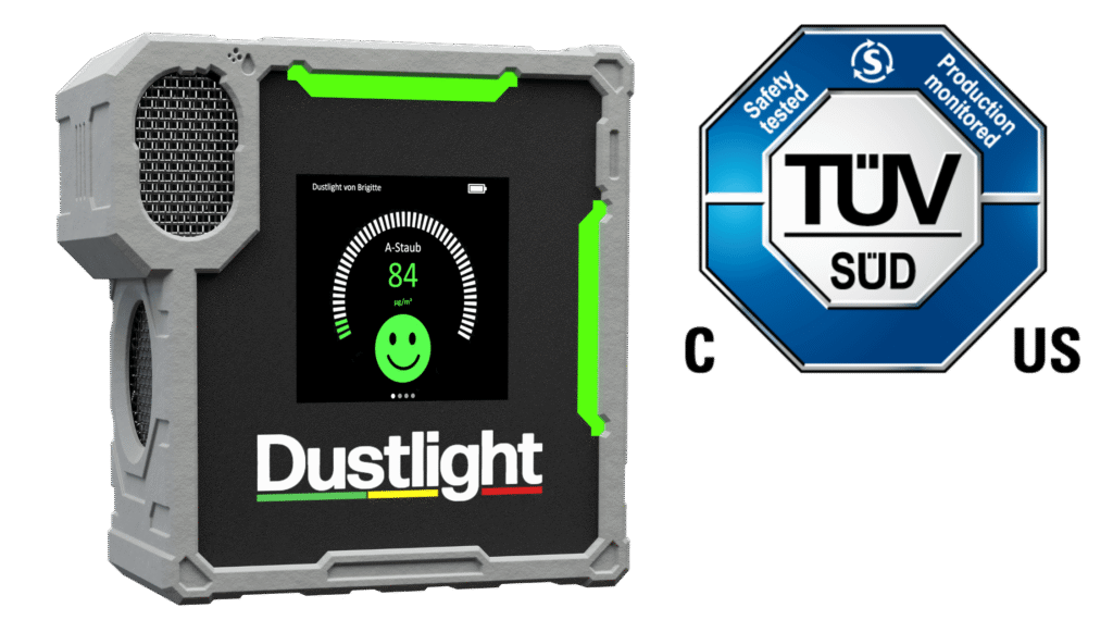 Dustlight Feinstaubmessgerät mit grünem Display und TÜV SÜD-Zertifizierungssiegel – tragbares Gerät zur Echtzeitüberwachung von A-Staub mit Smiley-Anzeige.