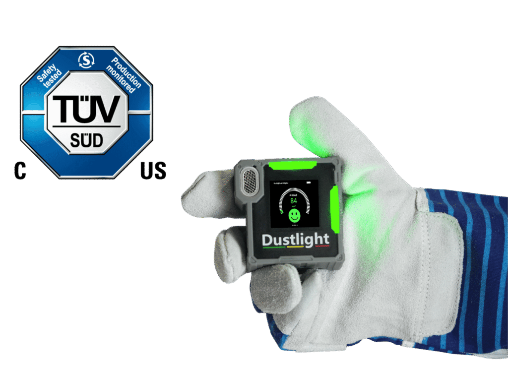 Dustlight Feinstaubmessgerät mit grünem Display und TÜV SÜD-Zertifizierungssiegel – tragbares Gerät zur Echtzeitüberwachung von A-Staub mit Smiley-Anzeige.